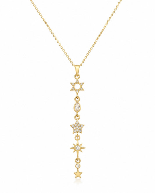 A gold lariat-style pendant necklace featuring a vertical line of star and moon motifs, some adorned with small clear stones, shown on a plain white background.