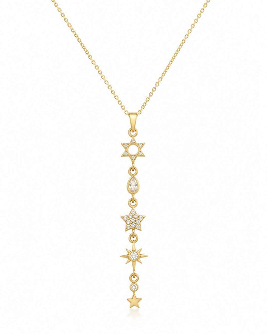 A gold lariat-style pendant necklace featuring a vertical line of star and moon motifs, some adorned with small clear stones, shown on a plain white background.