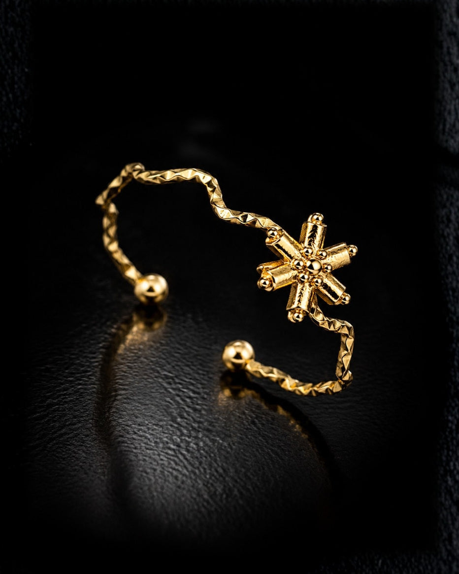 A delicate gold Y-necklace featuring a central cluster of small clear stones and two long dangling bead chains, shown on a plain white background.