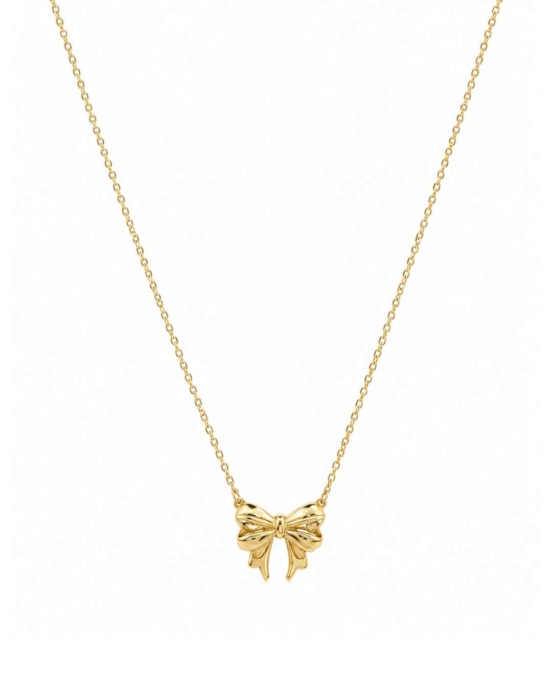 A delicate gold chain necklace featuring a small bow-shaped pendant, presented on a clean white background.