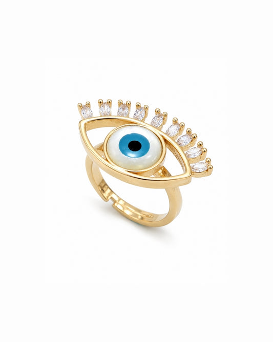 Gold evil eye ring with a blue and white eye motif and clear crystal accents on a white background.
