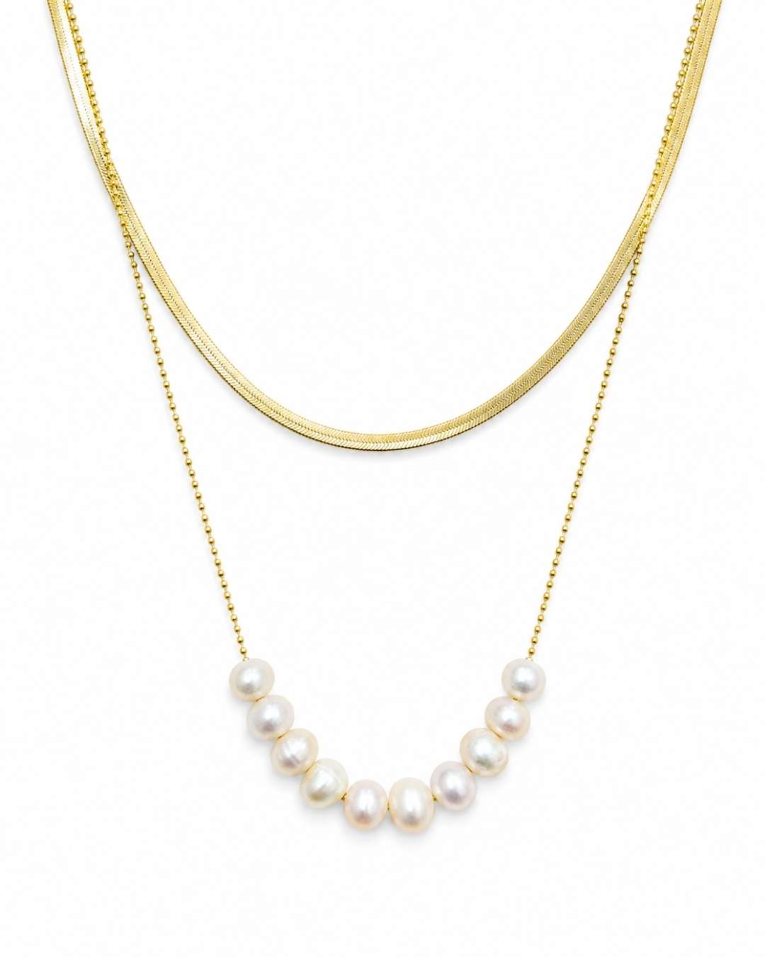 A double-layered gold necklace set on a white background, featuring a thick curved gold chain and a delicate gold beaded chain with a row of white freshwater pearls.