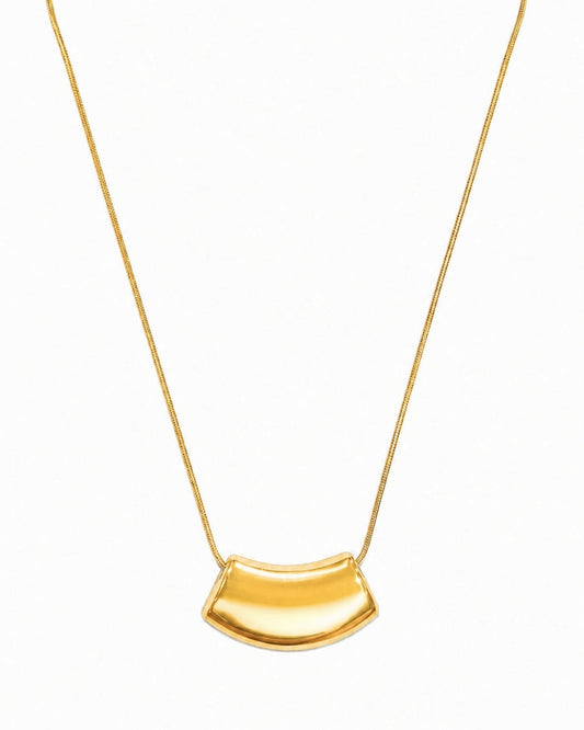 A gold necklace featuring a curved, semi-circular pendant on a delicate gold chain, presented against a plain white background.
