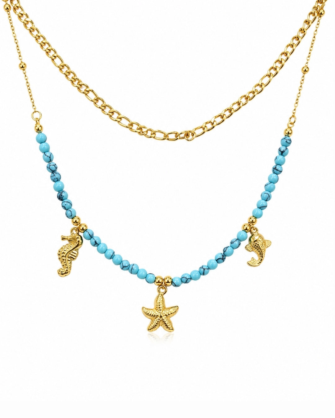 A double-layered necklace featuring a gold chain and a beaded strand of light blue beads with gold sea-themed charms, including a starfish, seahorse, and dolphin, on a white background.