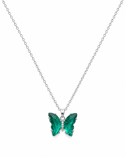A silver chain necklace with a butterfly pendant featuring vibrant green faceted crystal wings, set against a plain white background.