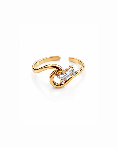 A gold-plated adjustable ring with a curved, intertwined design and a clear rectangular baguette-cut gemstone in the center, set against a plain white background.