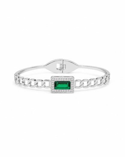 A silver-toned chain link bangle bracelet featuring a rectangular green emerald-cut center stone surrounded by small clear stones, shown on a plain white background.