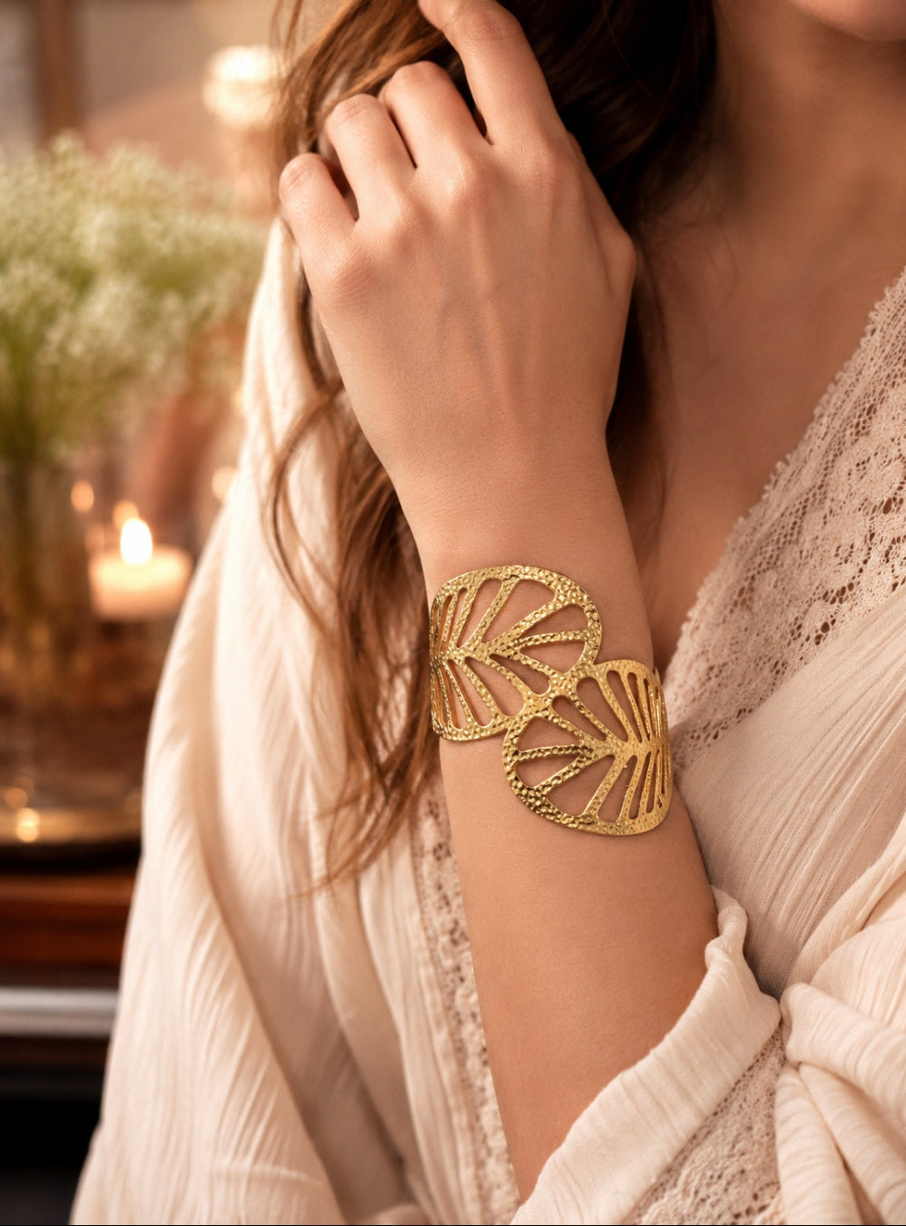 A delicate gold chain anklet with five small white pearl-like beads worn on a person's ankle, shown against a soft neutral background with a marble surface.