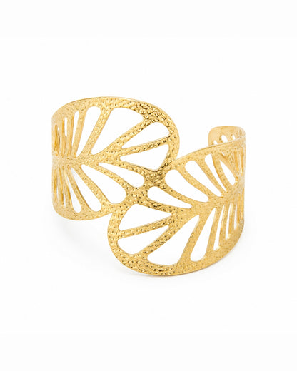 A textured gold cuff bracelet with a leaf-like openwork design, photographed on a clean white background.