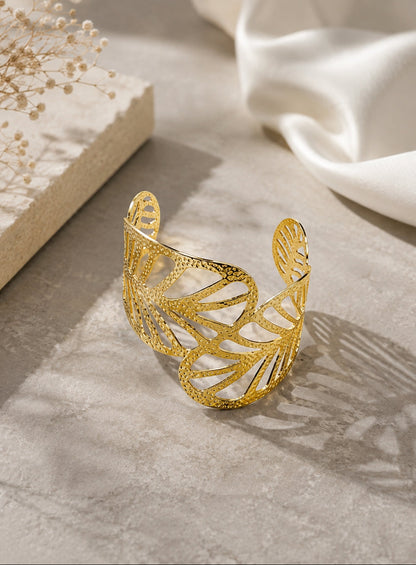 A delicate gold chain bracelet with five small white pearls and tiny gold beads, displayed on a white marble tray.