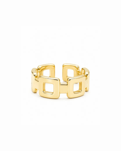 A gold geometric ring with a wide band composed of interlocking square links, shown on a plain white background.