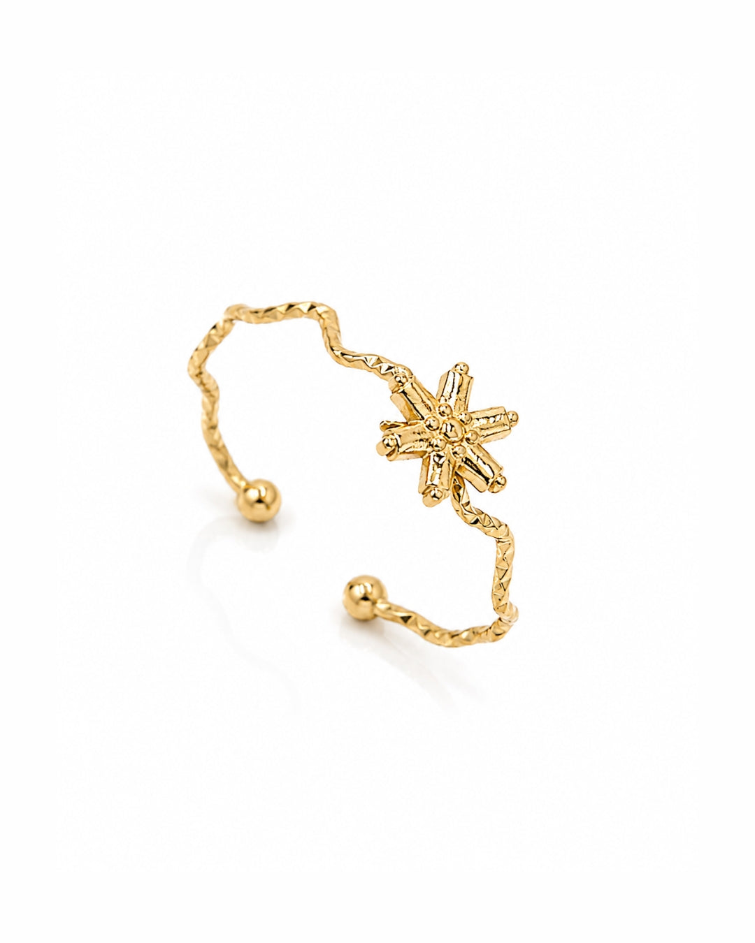 A gold open cuff ring featuring a textured, wavy band with small bead ends and a central six-pointed starburst charm, shown on a clean white background.
