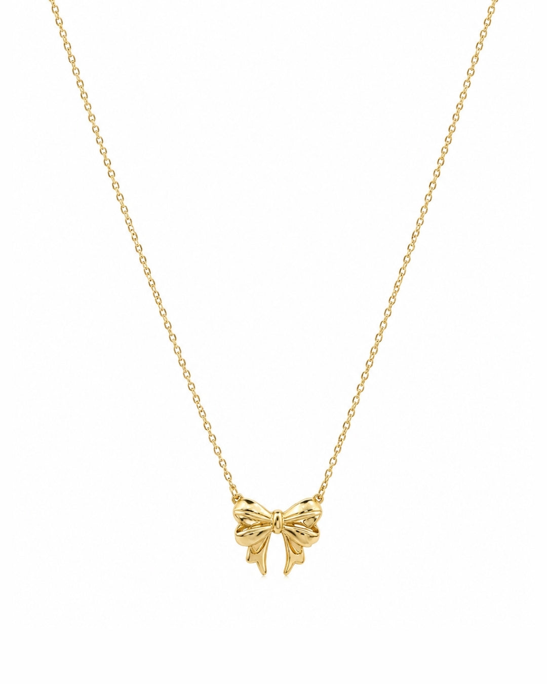 A delicate gold chain necklace featuring a small bow-shaped pendant, presented on a clean white background.
