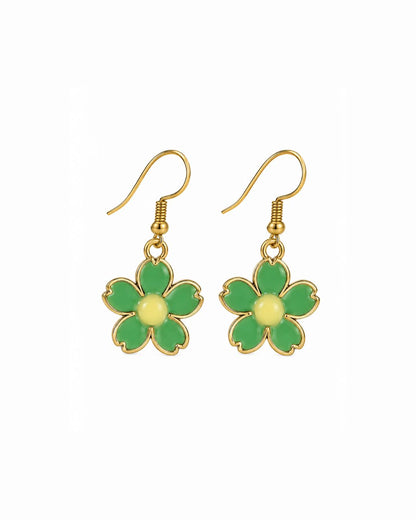 A pair of gold-tone dangle earrings featuring five green enamel flower petals with a pale yellow center, suspended from gold fishhook wires on a plain white background.