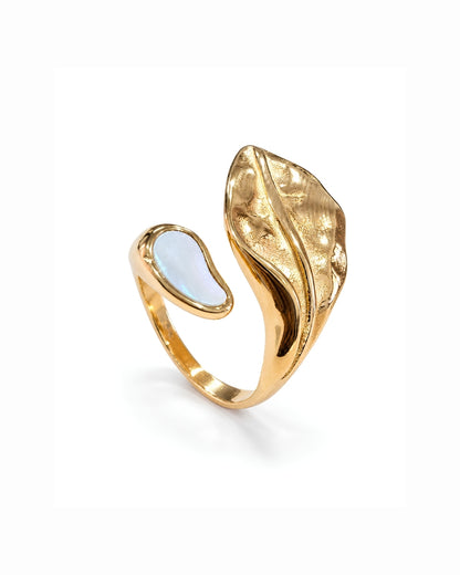 A gold-toned open ring with a textured, leaf-like curved element and a smooth, teardrop-shaped pale blue inlay, shown on a clean white background.