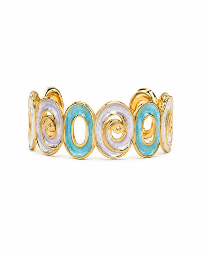 A gold-plated cuff bracelet featuring alternating oval links with light blue and white enamel inlays, set against a plain white background.