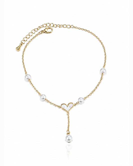 A delicate gold chain anklet featuring white pearl beads spaced along the chain, a small open heart design at the center, and a dangling pearl charm, shown on a clean white background.