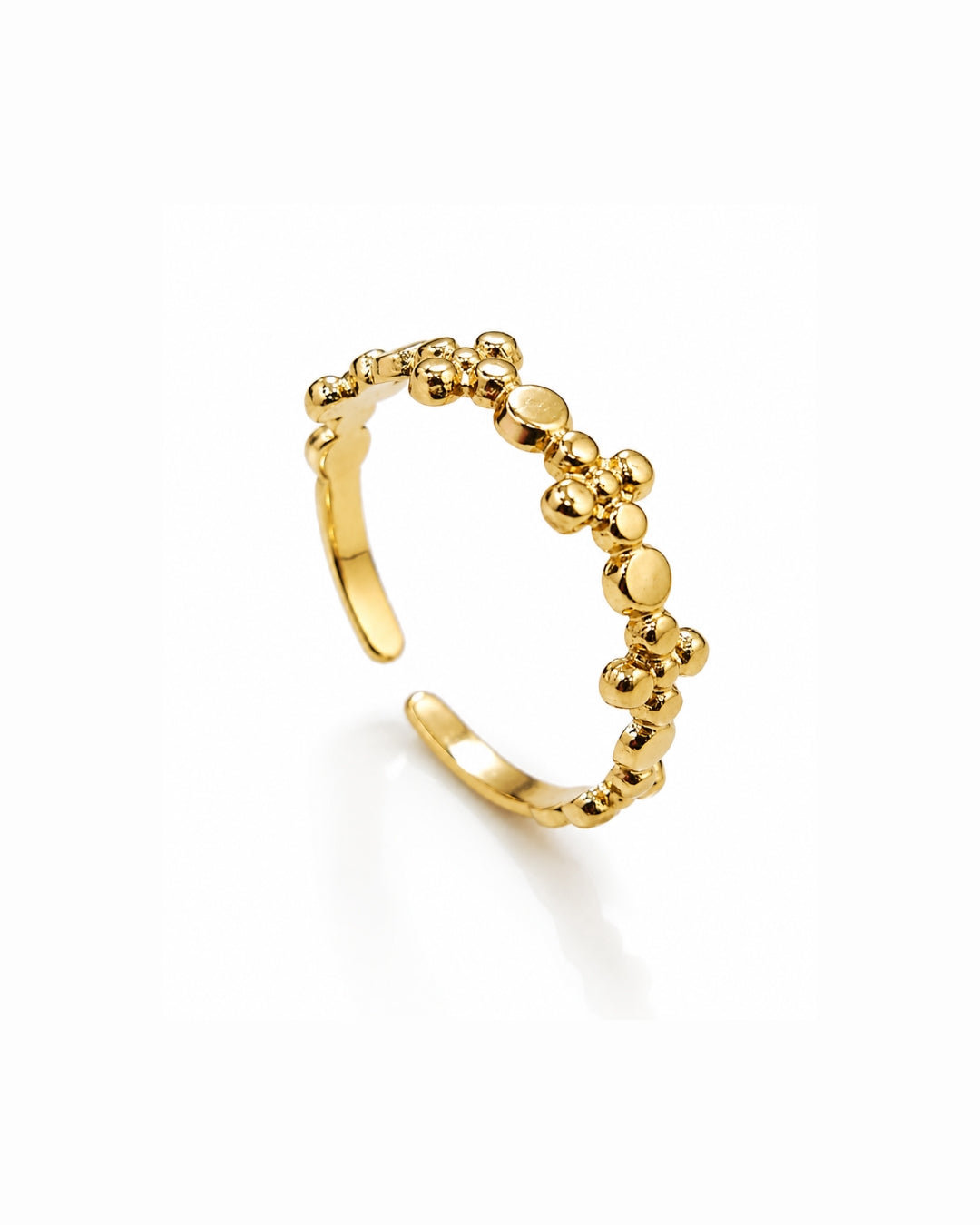 A gold open cuff ring decorated with a textured, raised beaded pattern along the top curve, shown on a clean white background.