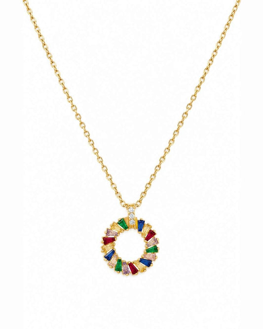 A gold chain necklace with a circular pendant featuring colorful, faceted gemstone segments in red, green, blue, purple, and clear stones, set against a plain white background.