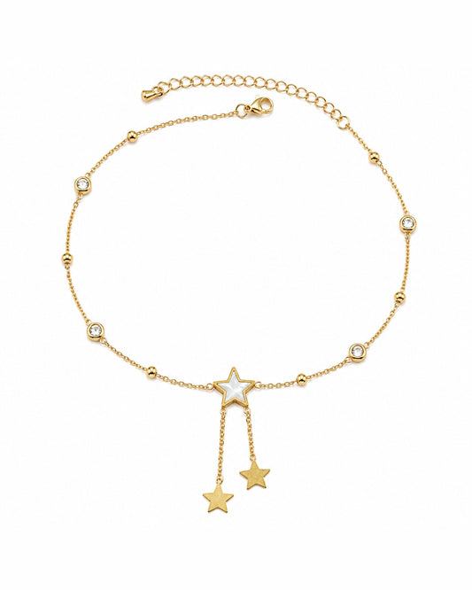 A delicate gold chain anklet featuring a central star charm with a white inlay, flanked by two dangling star charms at the bottom, and small bezel-set clear stones spaced along the chain. The anklet is displayed on a clean white background.