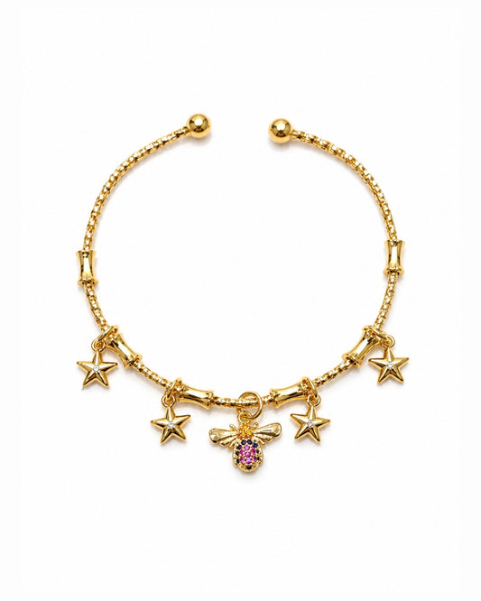 A gold-plated charm bracelet featuring five star charms and a central bee charm embellished with a pink gemstone, displayed on a clean white background.
