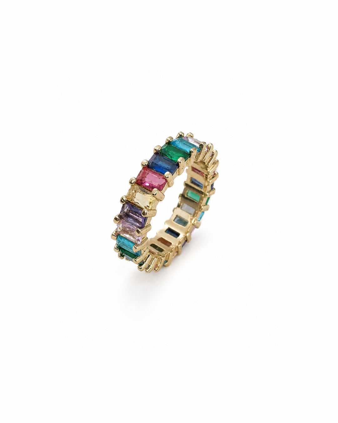 A gold eternity ring featuring a row of colorful baguette-cut gemstones, including pink, blue, green, and purple, set against a plain white background.
