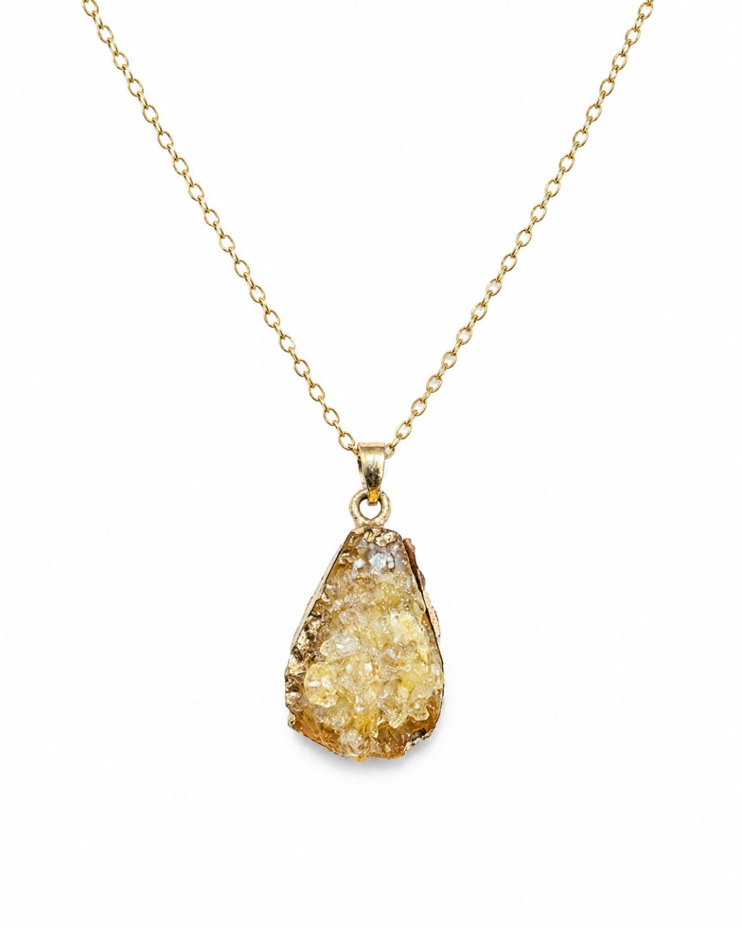 A gold chain necklace with a teardrop-shaped druzy pendant featuring a textured, crystalline yellow and gold surface, set against a plain white background.