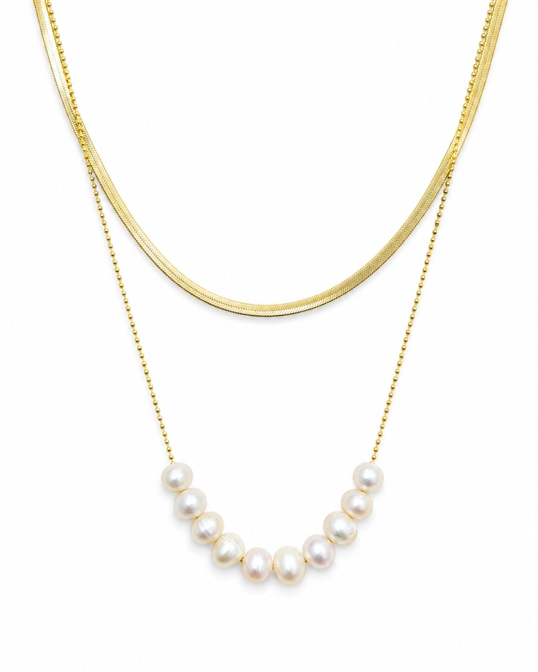 A double-layered gold necklace set on a white background, featuring a thick curved gold chain and a delicate gold beaded chain with a row of white freshwater pearls.