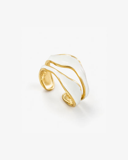 A gold and white wave-shaped cuff ring, photographed on a clean white background.