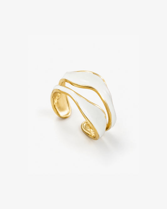 A gold and white wave-shaped cuff ring, photographed on a clean white background.